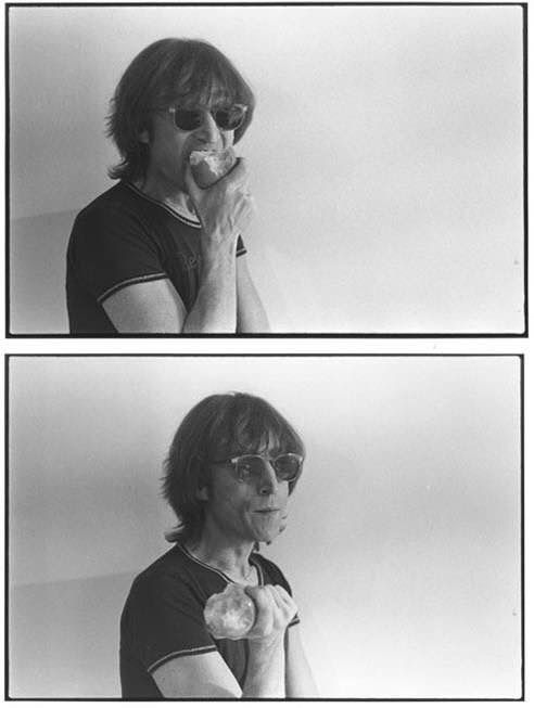 black and white photograph of man eating doughnut