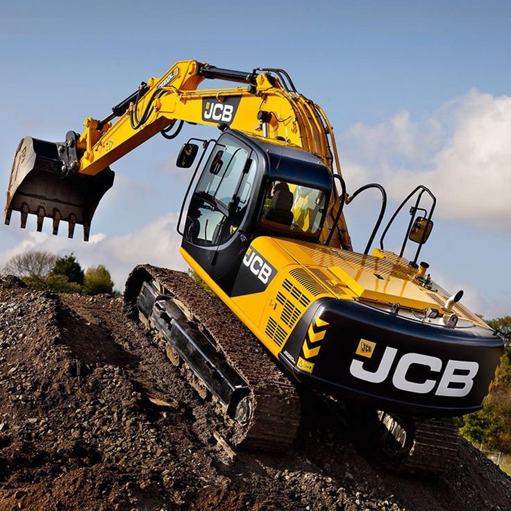 the jcb excavator is on top of a pile of dirt and rocks