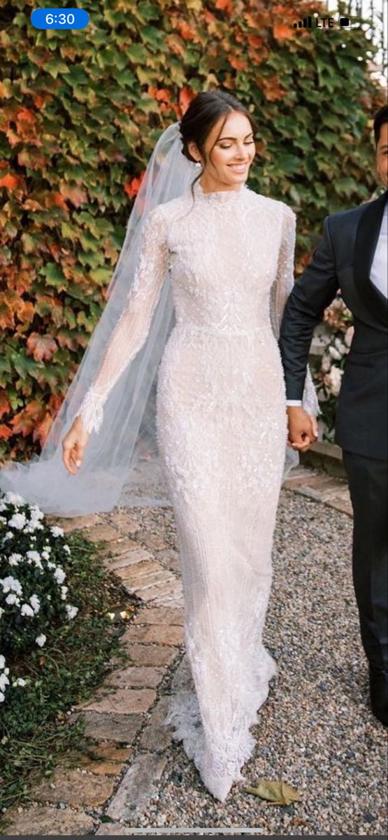 a bride and groom holding hands walking together