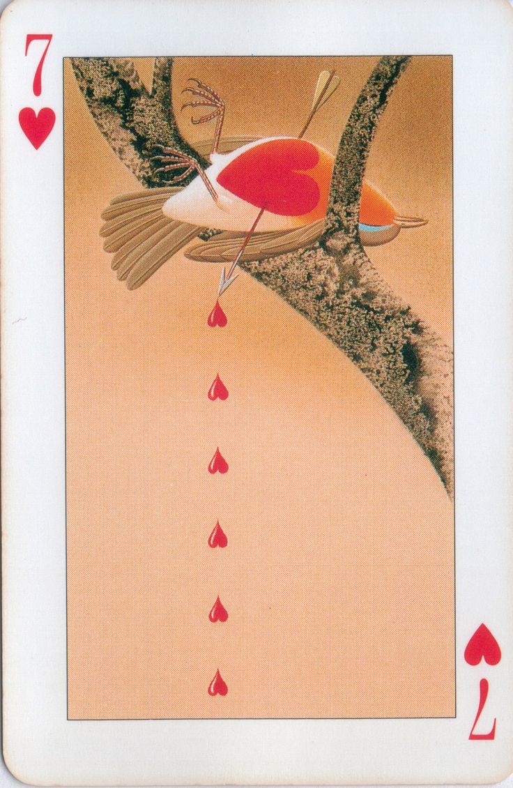 a playing card with a bird and hearts on it's back, hanging from a tree branch