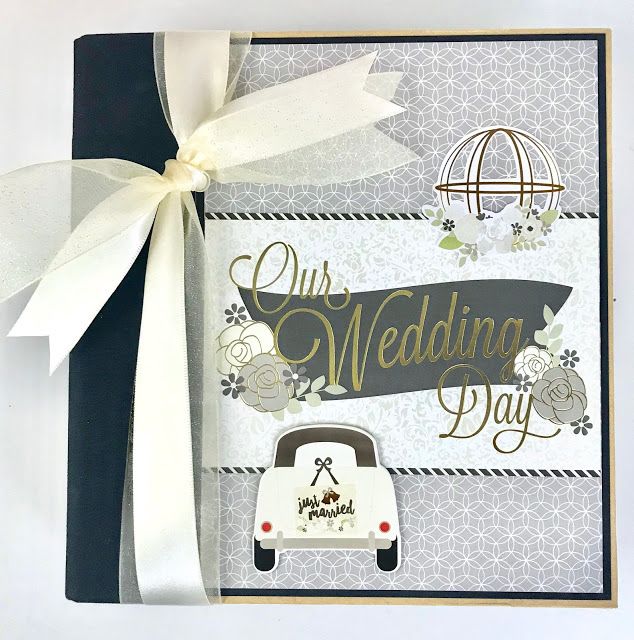 a wedding card with a white ribbon on it and a car in the background that says our wedding day