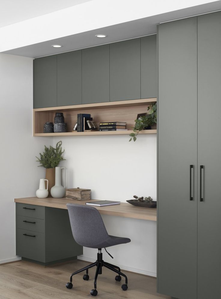 an office with grey cupboards and a gray chair in front of a wooden desk