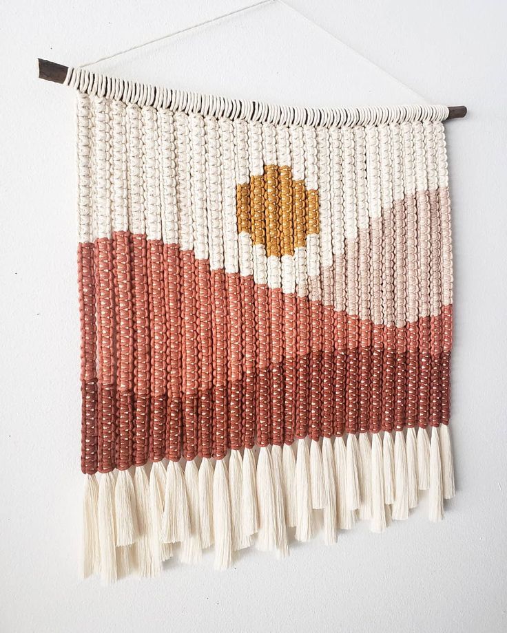 the wall hanging is decorated with beads and tassels, which are red white and orange