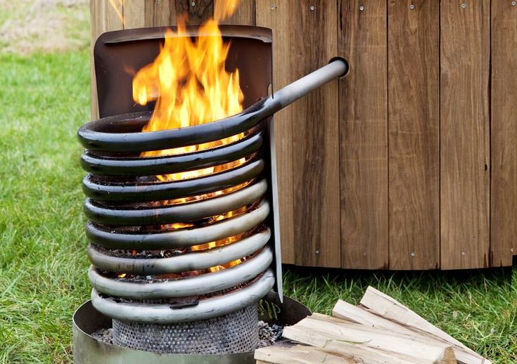 an outdoor fire pit with logs in the grass