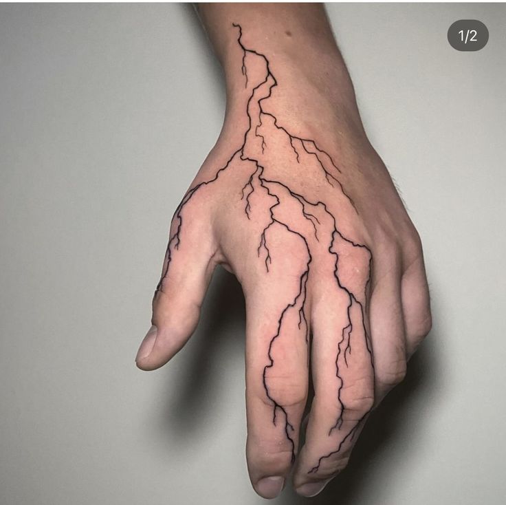 a person's hand with lightning tattoo on it