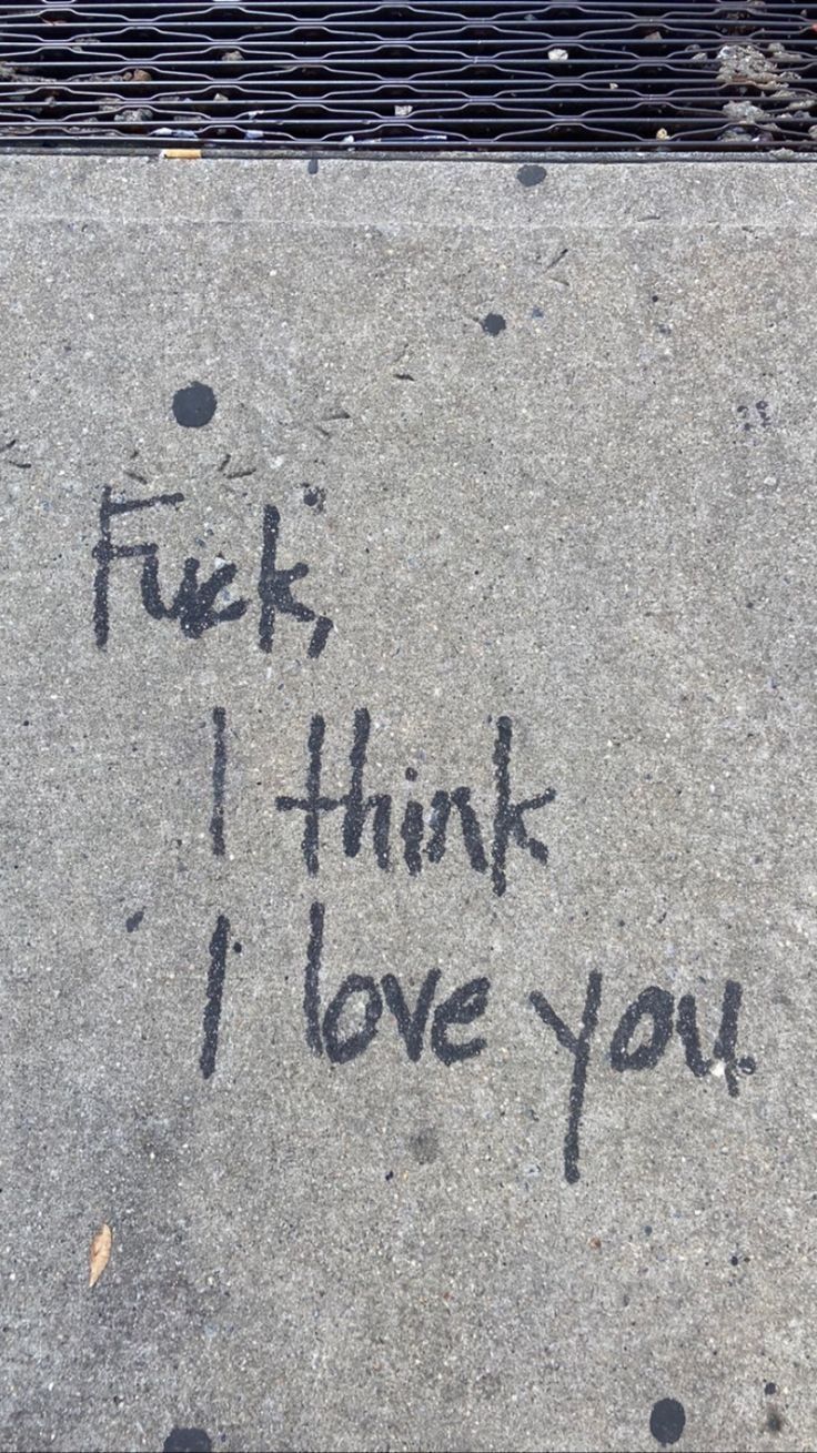 graffiti written on the sidewalk in front of a fire hydrant that says, f k i think i love you