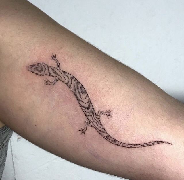 a small lizard tattoo on the arm