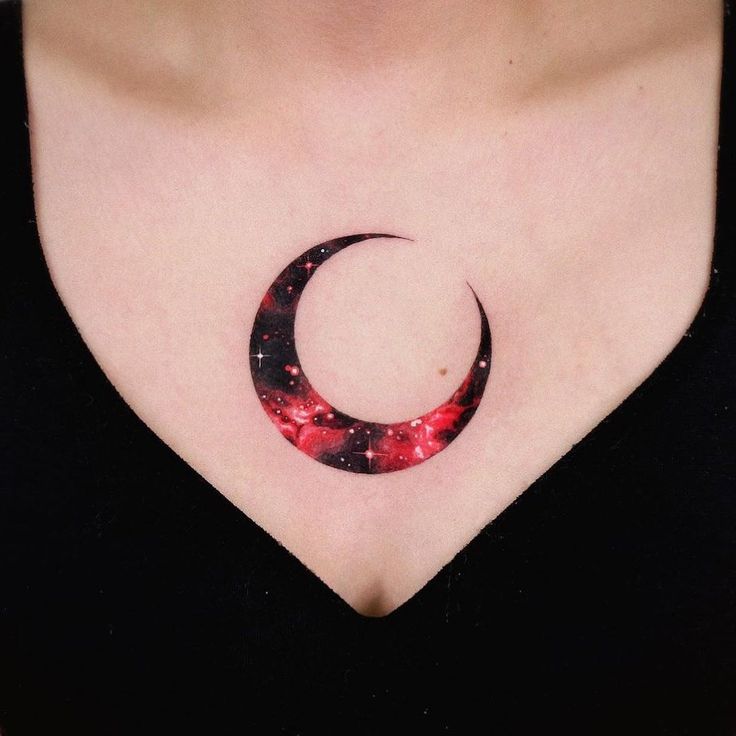 a woman's chest with a crescent tattoo on it