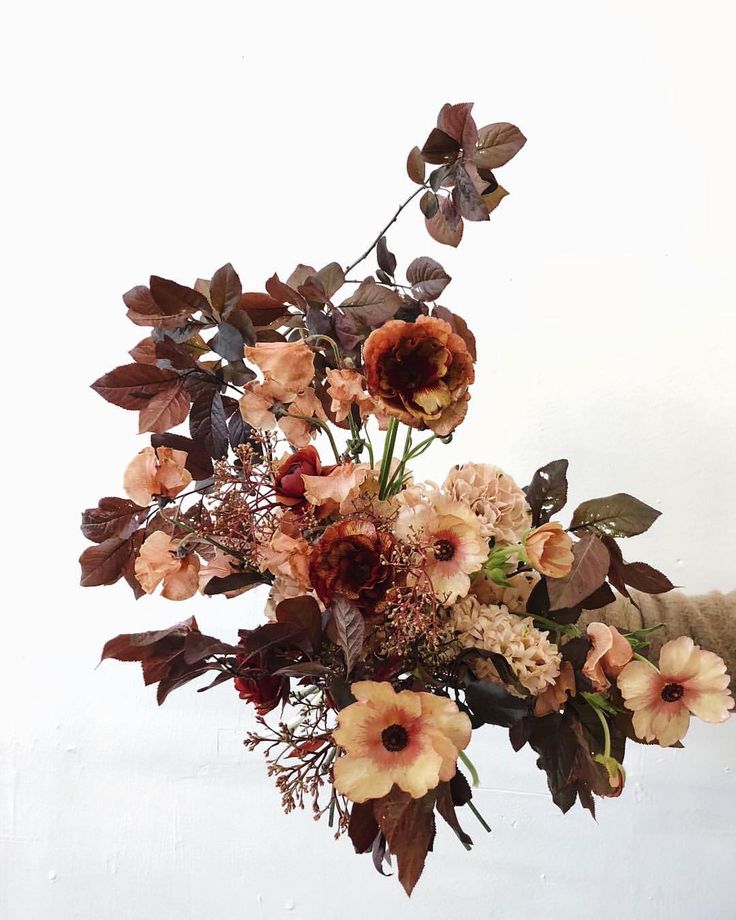 a vase filled with lots of flowers on top of a table