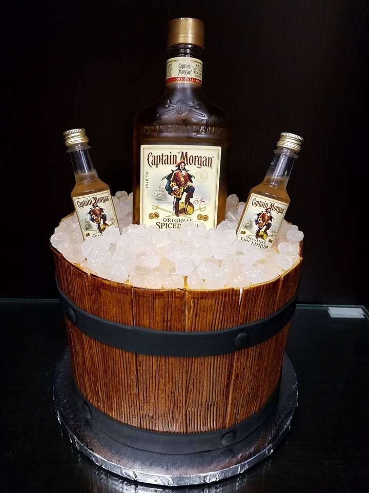 a wooden barrel filled with ice and two bottles of whiskey sitting on top of it