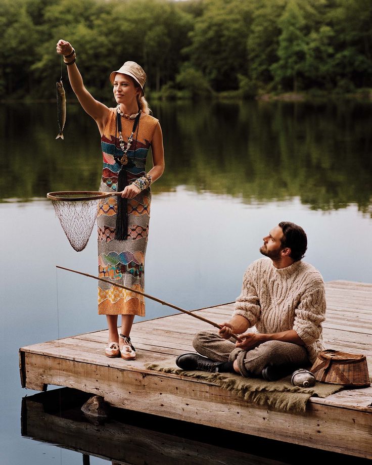 a woman standing next to a man on a dock with a fishing rod in his hand