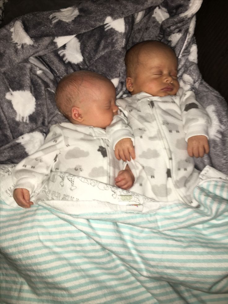 two baby babies laying on top of a blanket