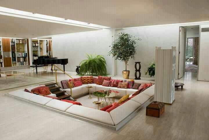 a living room filled with lots of furniture and a large plant in the middle of it