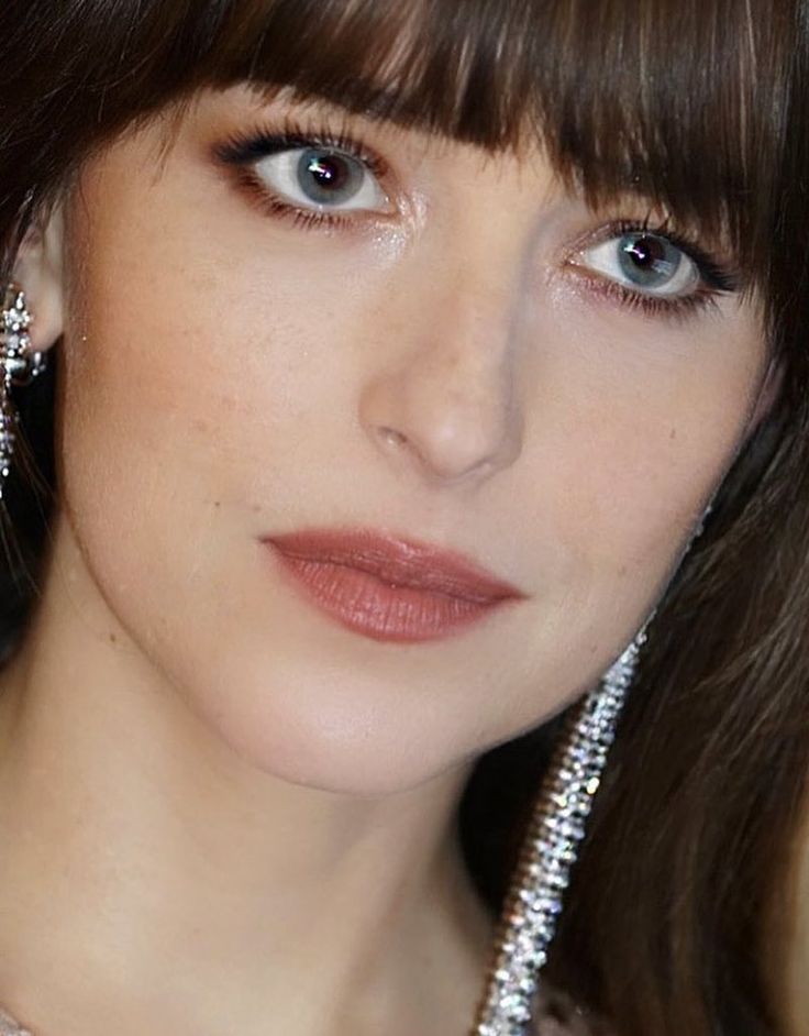 a close up of a person wearing earrings and a necklace with pearls on it's neck