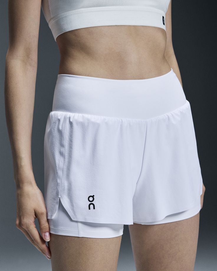 Move like lightning with the Court Shorts. With integrated tights for comfortable wear during tournaments or workouts. The Court Shorts are built for smooth movements on the court. Sleek and streamlined, they feature a discreet zipped pocket on the back. So you can store your valuables without sacrificing on comfort or agility. Ready to fly across the court? These shorts feature secure inner tights to ensure a distraction-free fit. Take on powerful moves, slide into shots and rally with intensit White Sports Bottoms With Contoured Waistband, White Training Shorts With Pockets, White Bottoms With Contoured Waistband And 4-way Stretch, White Stretch Activewear With Pockets, Compressive White Athletic Shorts With Go-dry, Functional White Activewear With Built-in Shorts, Sporty Activewear With Pockets For Light Sports, White Compression Athletic Shorts With Moisture-wicking, White 4-way Stretch Athletic Shorts For Training