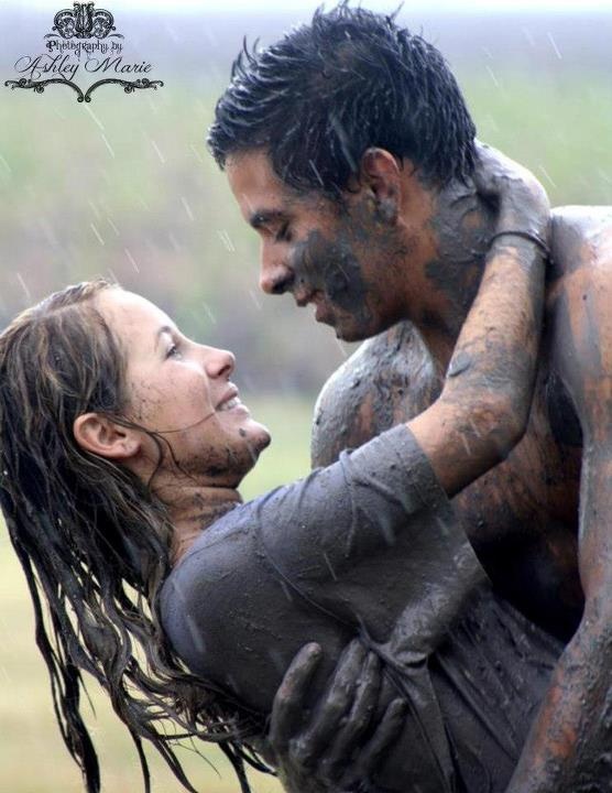 a man and woman covered in mud hugging each other with the words,'love is all you need '