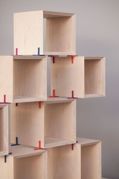 several wooden shelves with red and blue pegs on them