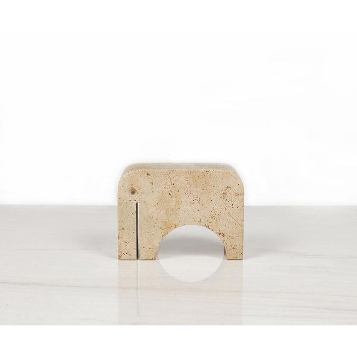 a small wooden object sitting on top of a white counter next to a wall and floor