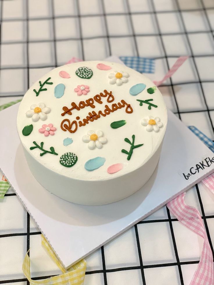 a white birthday cake sitting on top of a table