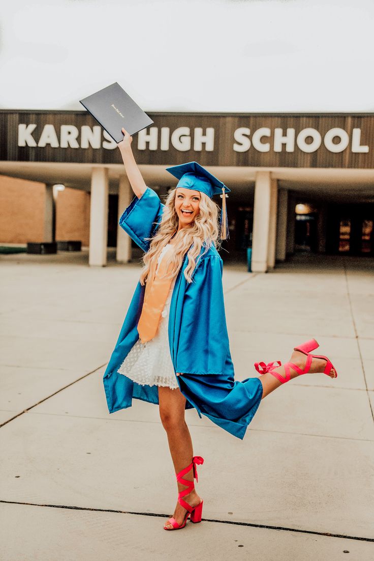 a woman in a graduation cap and gown is holding up her diploma while posing for the camera