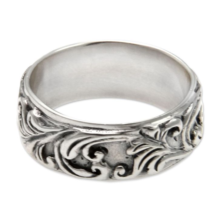 an ornate silver ring on a white background