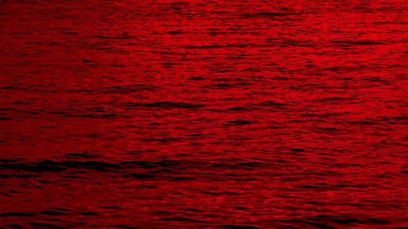 the sun is setting over the water and it looks to be very red in color