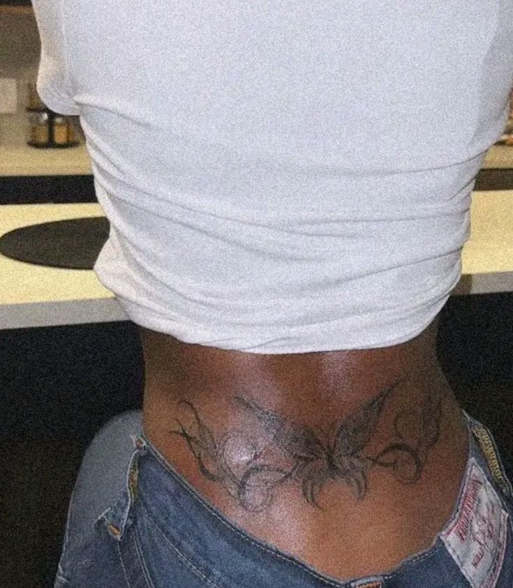 the back of a woman with tattoos on her stomach