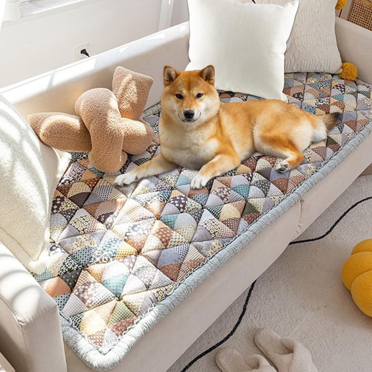 a dog is laying on a bed with pillows and a stuffed animal next to it