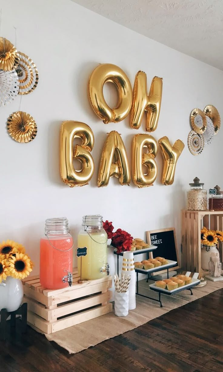 a baby shower party with sunflowers, cake and balloon letters on the wall