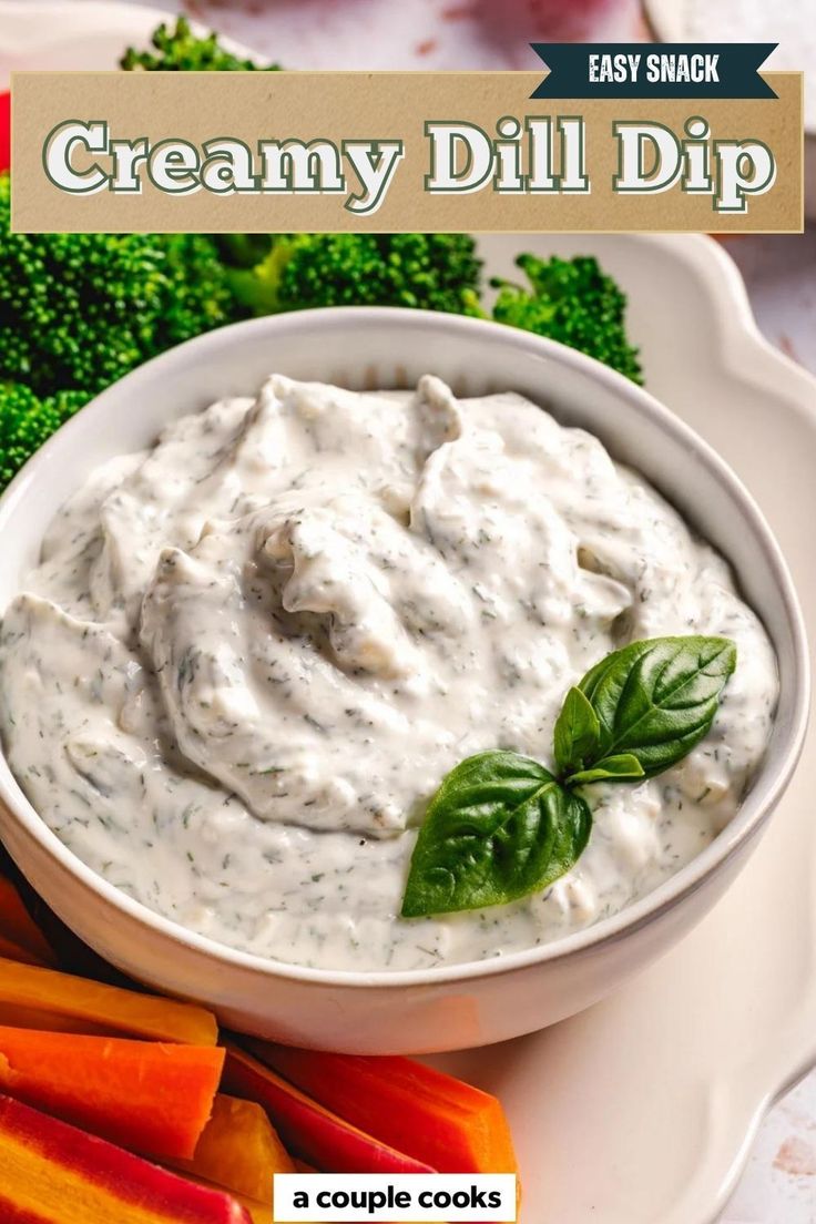 creamy dill dip in a white bowl surrounded by broccoli and carrots