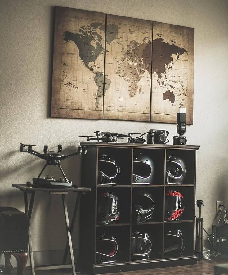 a room with a bike rack and two large maps on the wall above it,