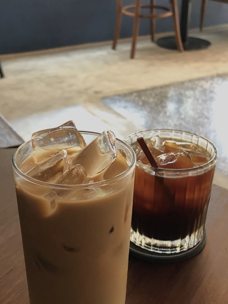 two drinks sitting on top of a table next to each other