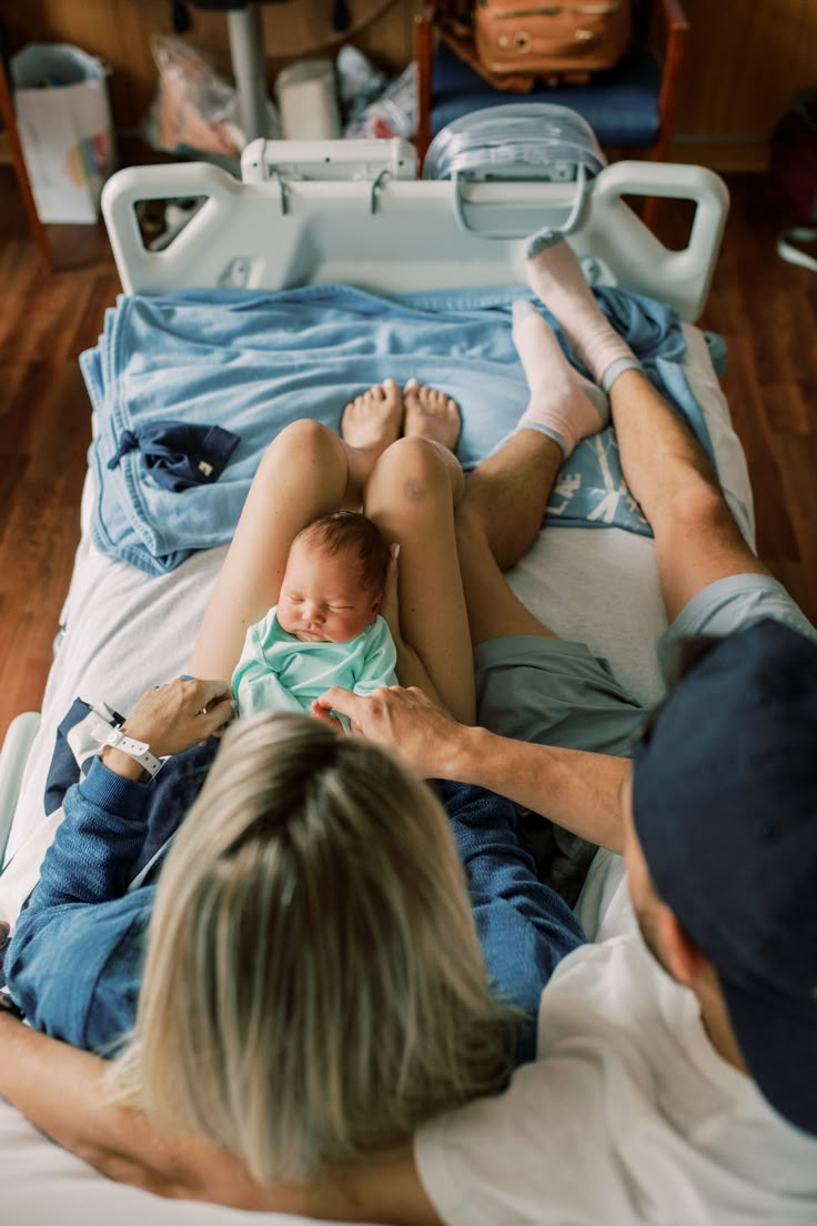 a man and woman laying in bed with a baby