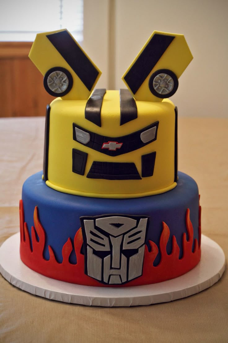 a three tier cake decorated to look like a transformer head with flames on it