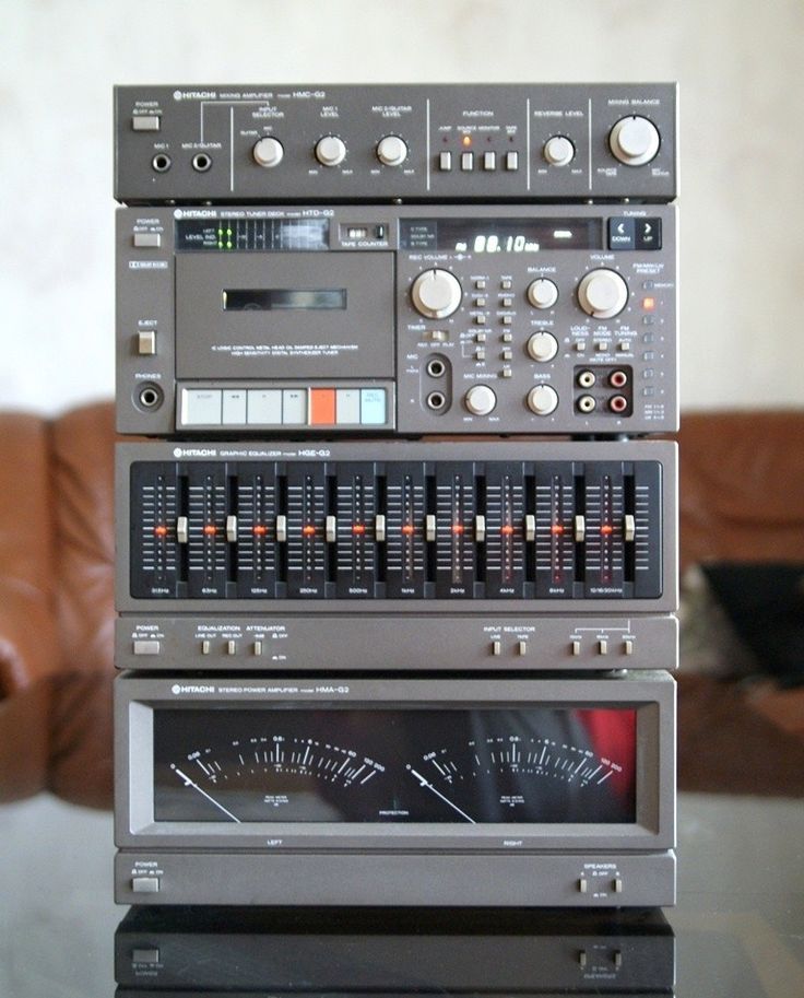 three electronic devices stacked on top of each other in front of a brown leather couch