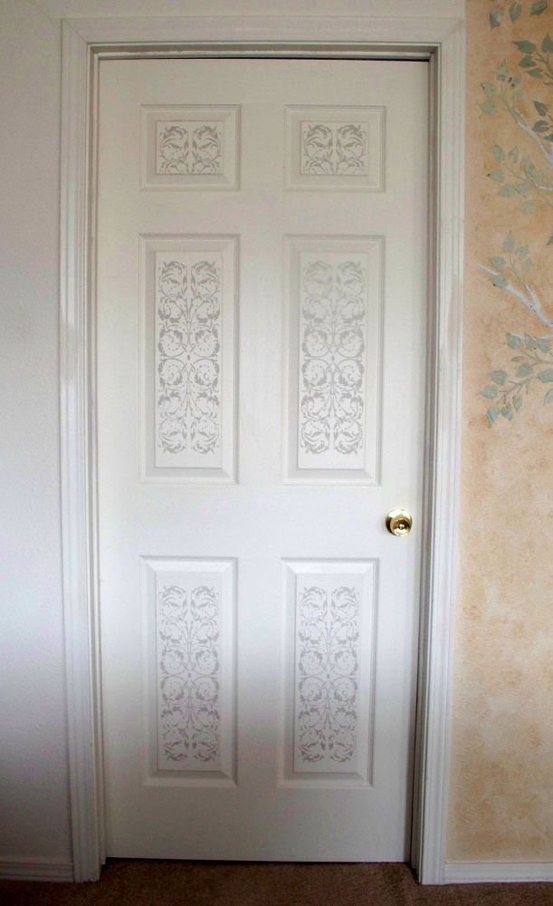 a white door in a room next to a wall with floral designs on the walls