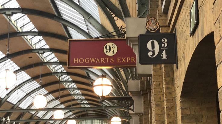 the hogwart's express sign is hanging from the ceiling in an old train station