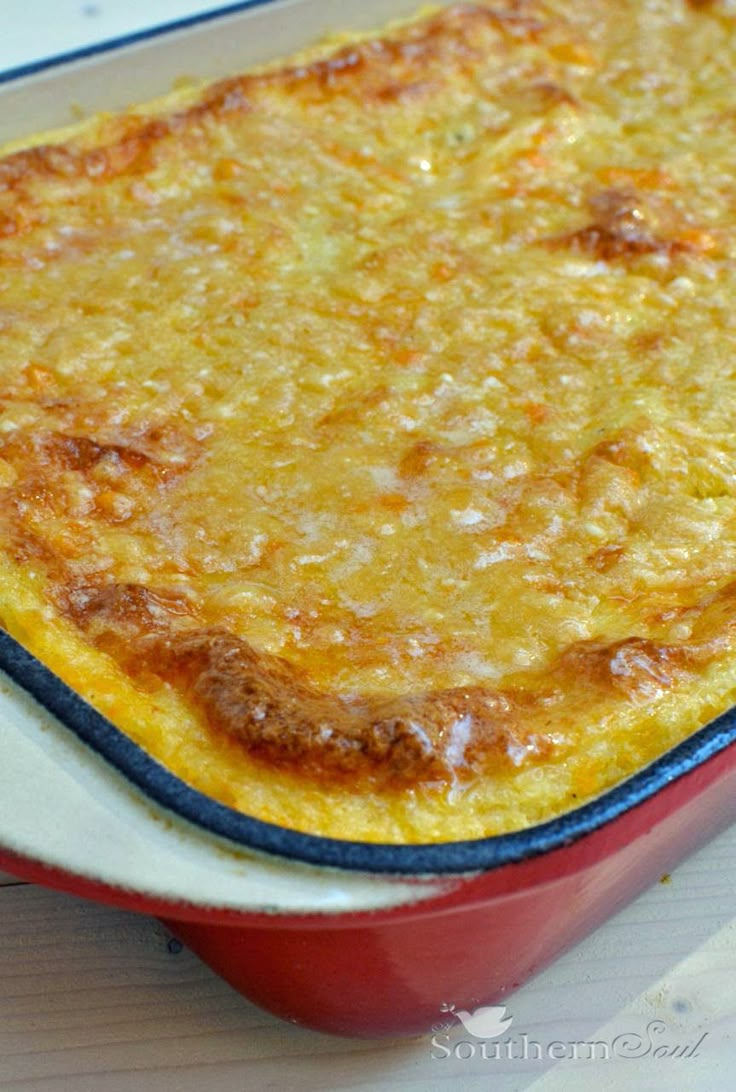 a red casserole dish with cheese on top