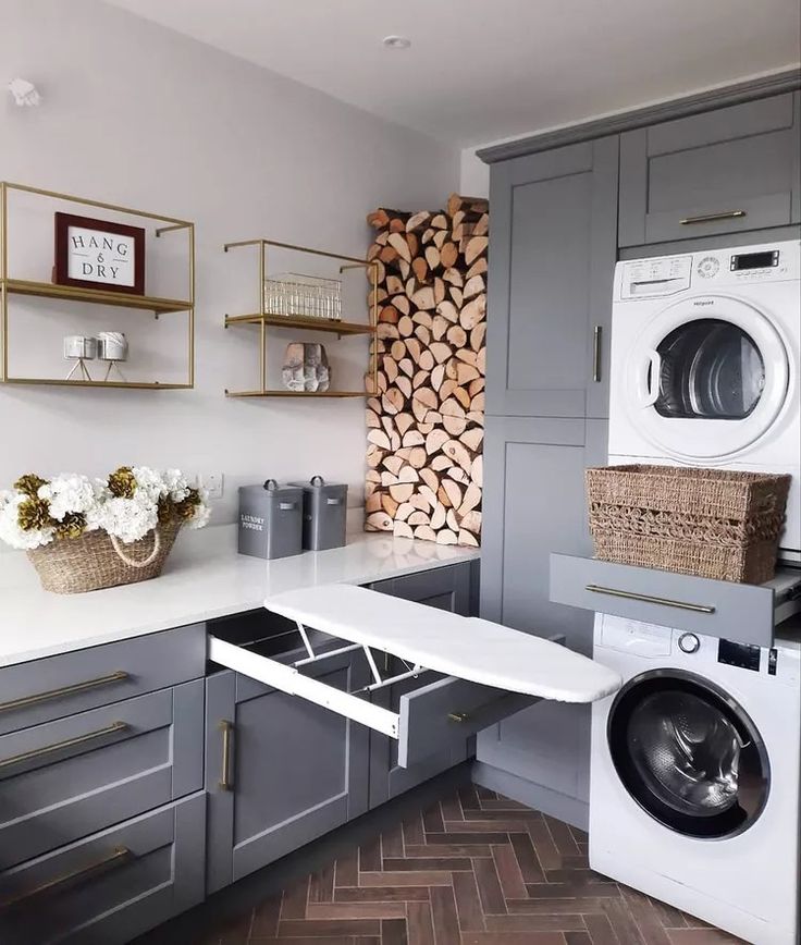 a washer and dryer in a small room with wood stacked on the wall