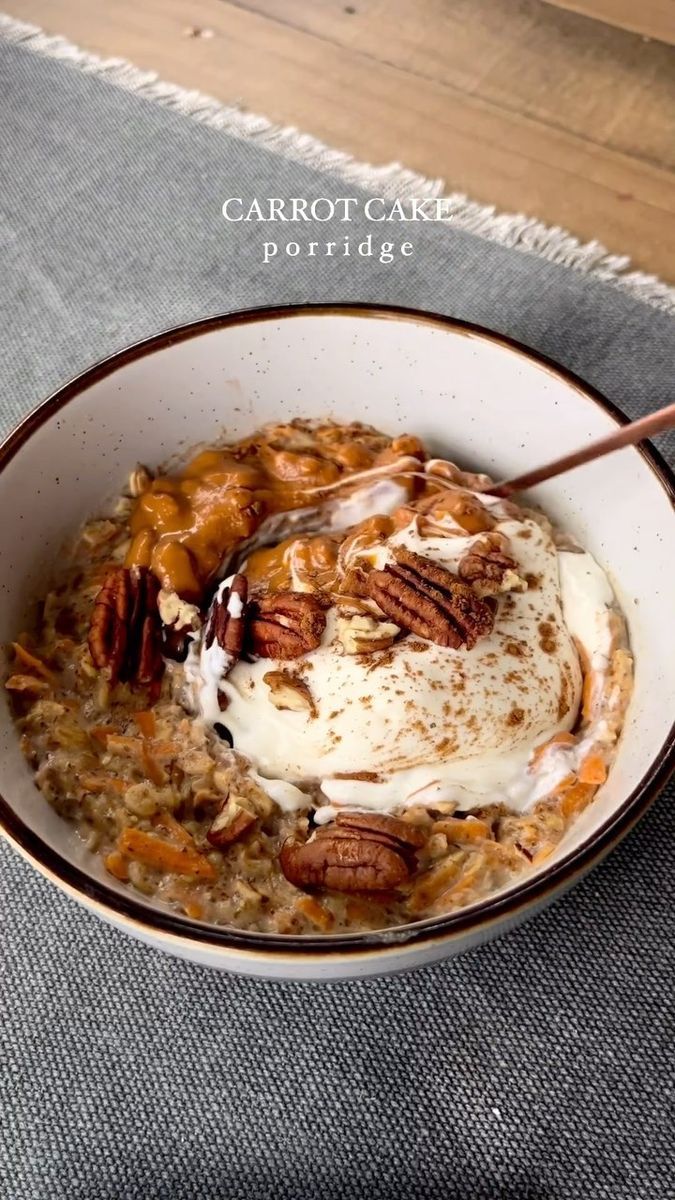 a bowl filled with oatmeal topped with pecans and whipped cream on top