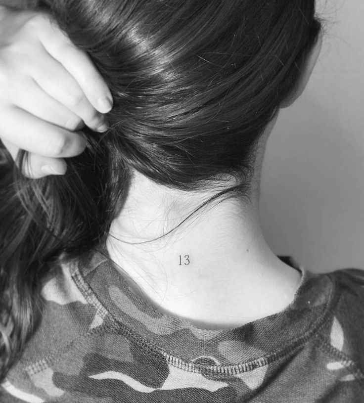 a woman's neck tattoo with the number thirteen on her left upper back side