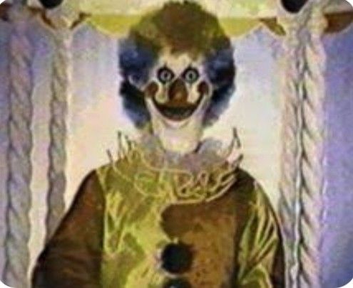 an animated clown is standing in front of a curtain with his face painted yellow and blue