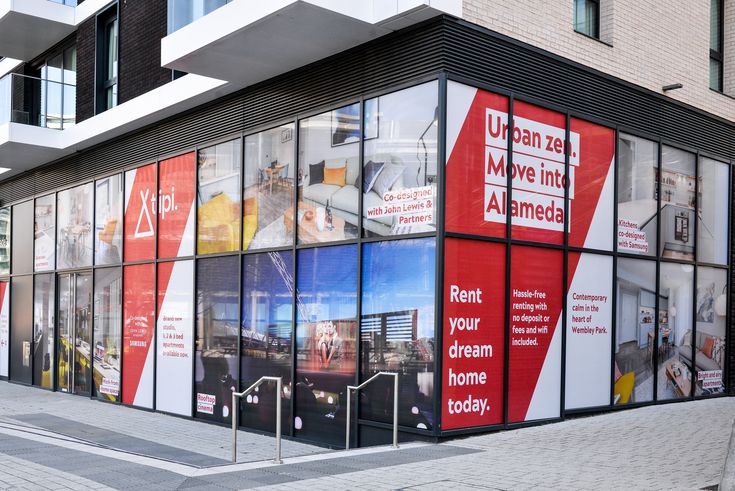 an office building with many windows and advertisements on the side of it's wall