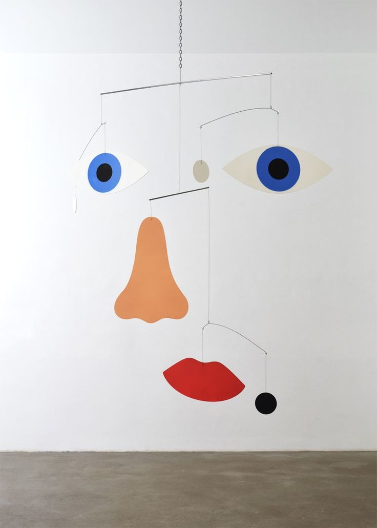 a white wall with an abstract painting hanging from it's sides and two blue eyes on each side