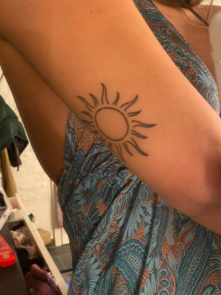 a woman with a sun tattoo on her arm