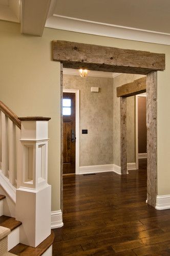 an empty entryway with wood floors and white trim on the walls, along with wooden banisters