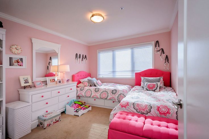 a bedroom with pink walls and white furniture in the room, including two twin beds