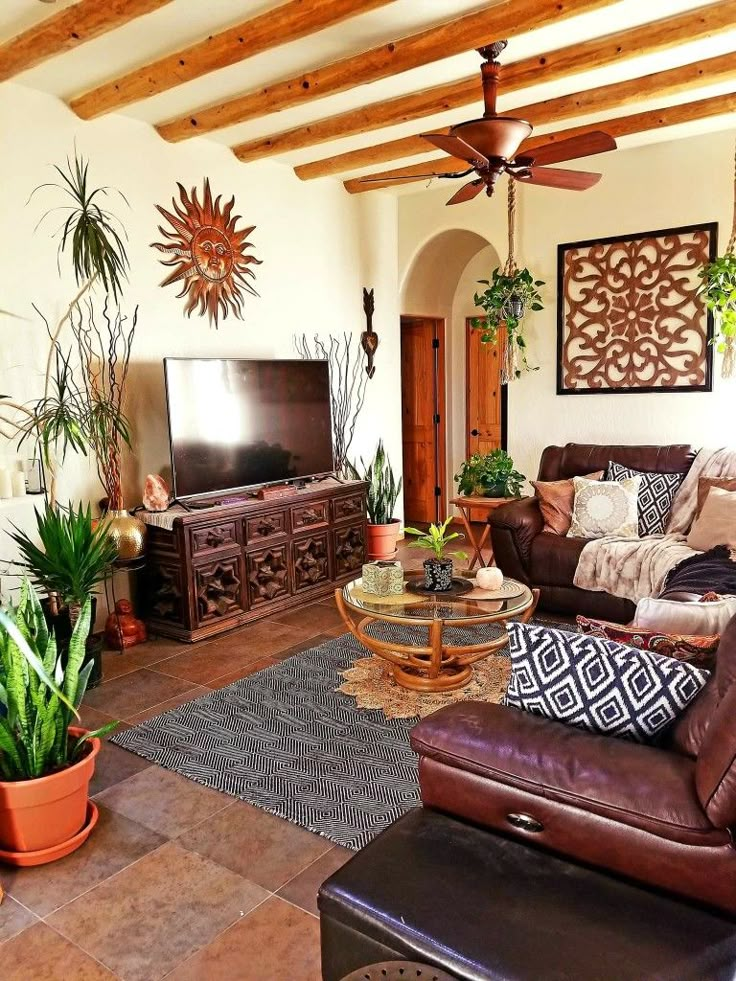 a living room filled with lots of furniture and plants on top of the table in front of a flat screen tv