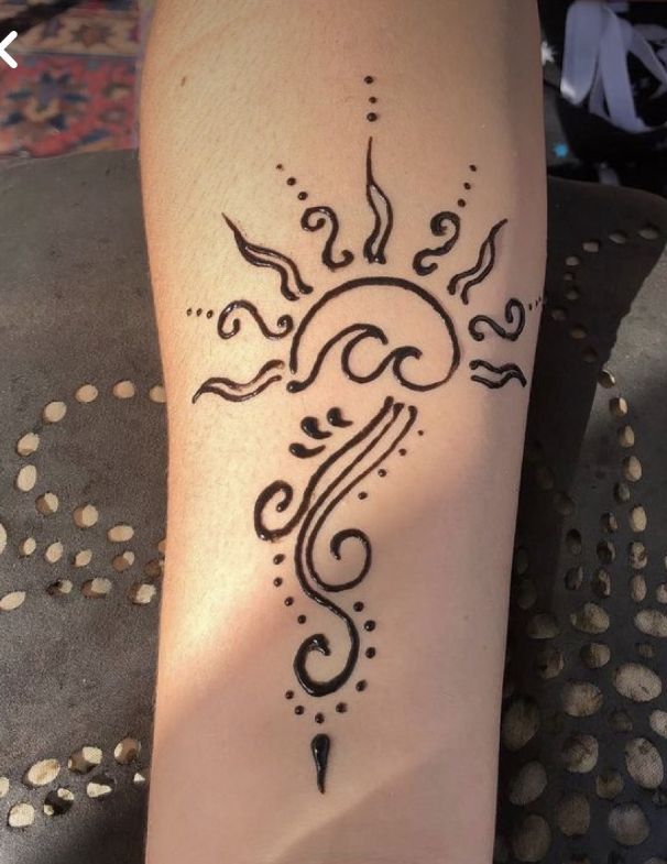 a woman's leg with a tattoo on it that has an image of a sun