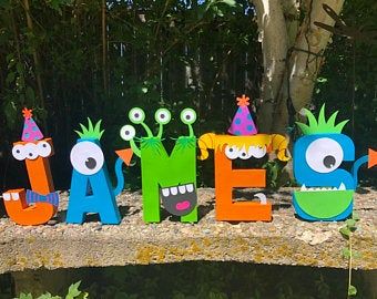 the letters are made out of wood and decorated with cartoon characters, such as monsters